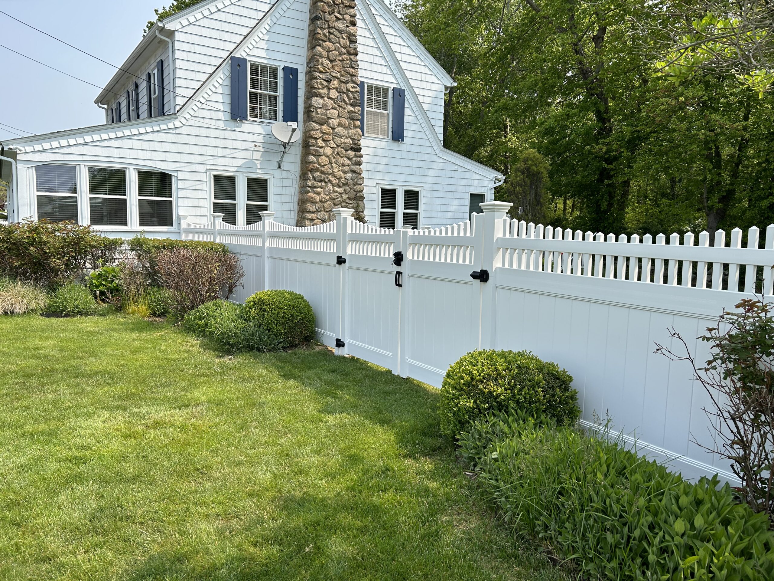White vinyl privacy fence transitioning to picket with scalloped topper